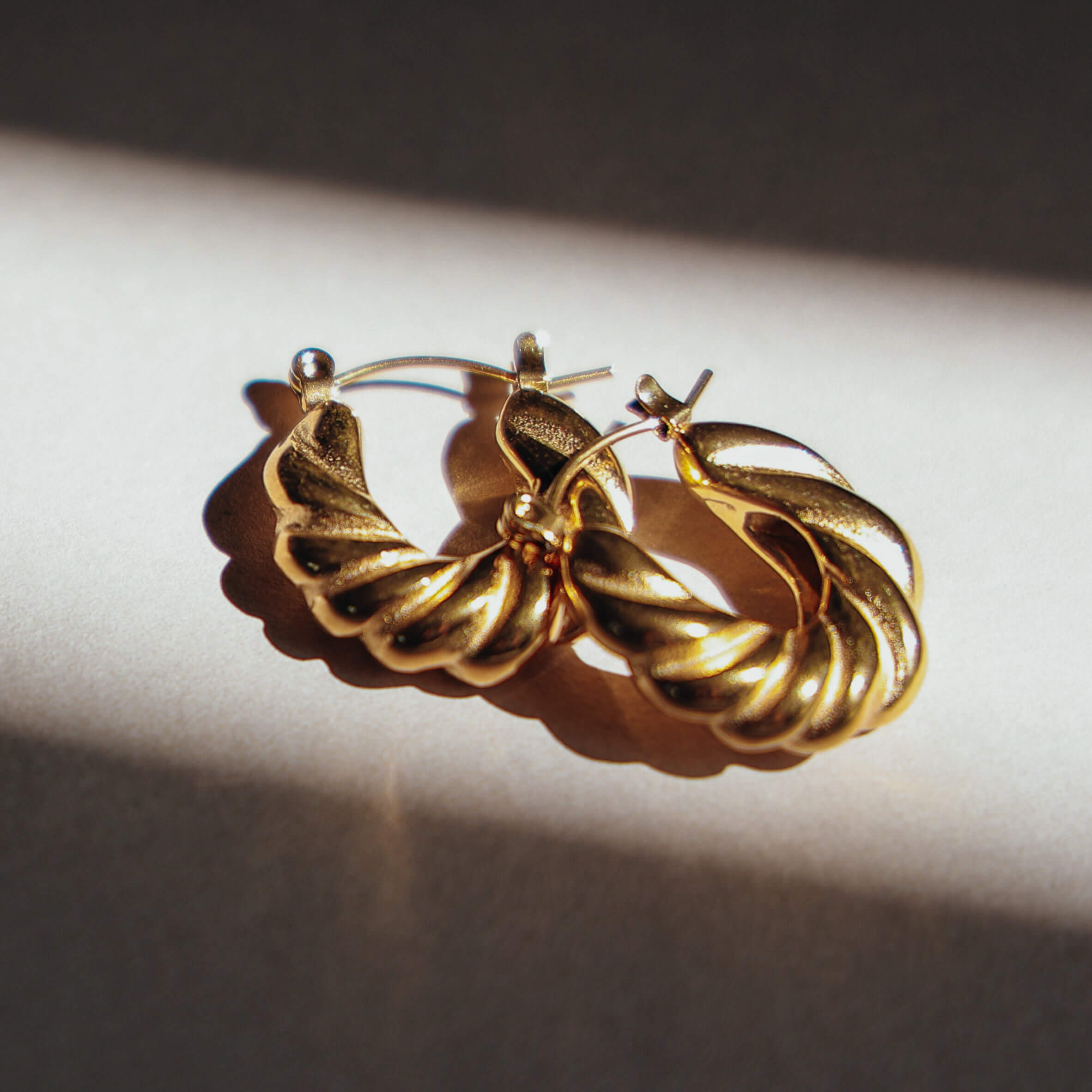 Gold hoop earrings on a light background