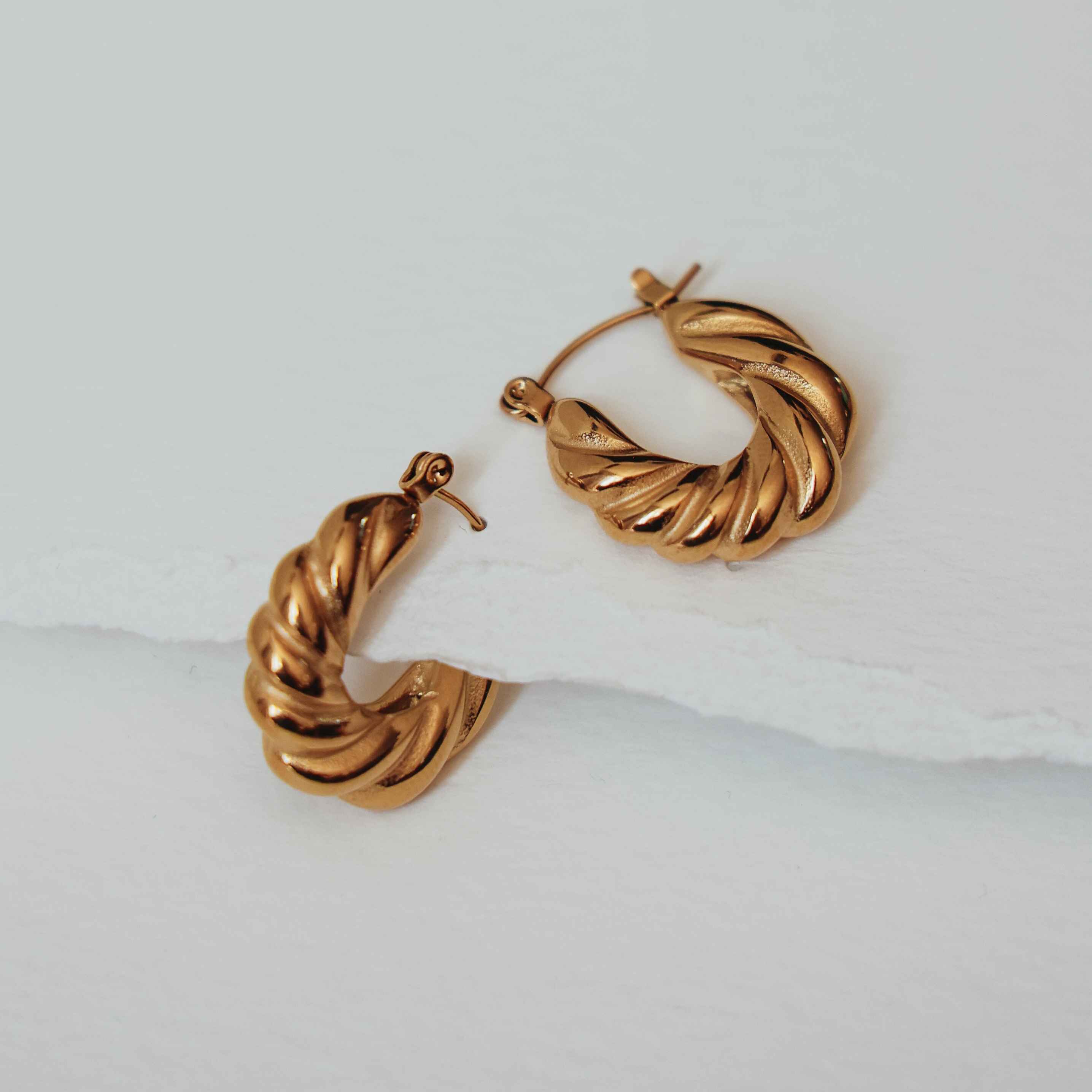 Pair of gold hoop earrings on a light background
