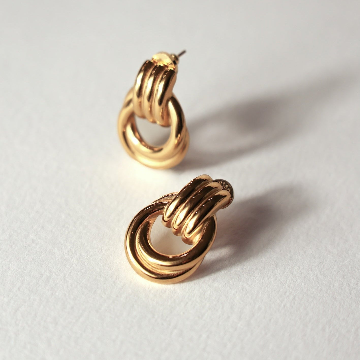 Pair of gold hoop earrings on a light gray background
