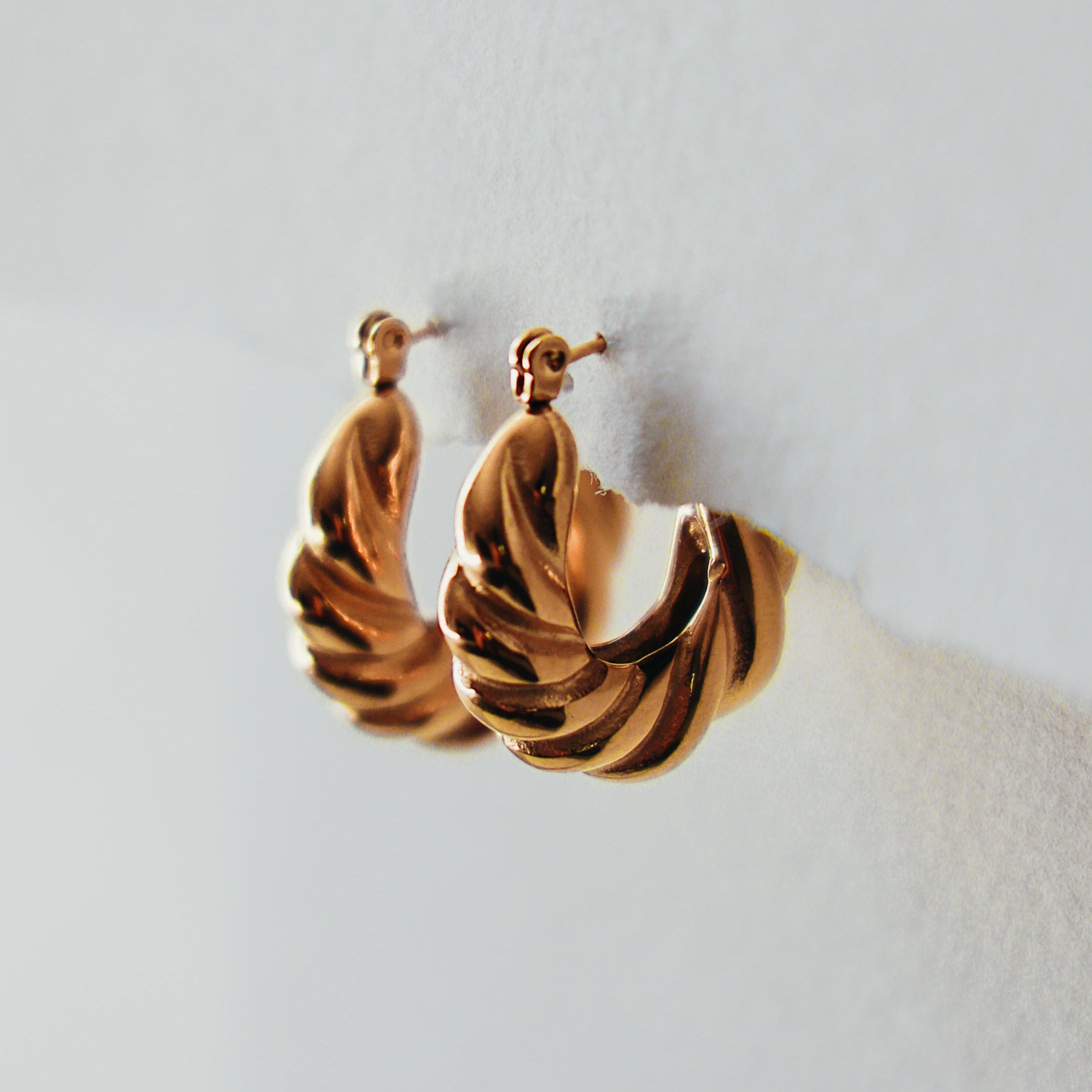Pair of gold hoop earrings on a light background
