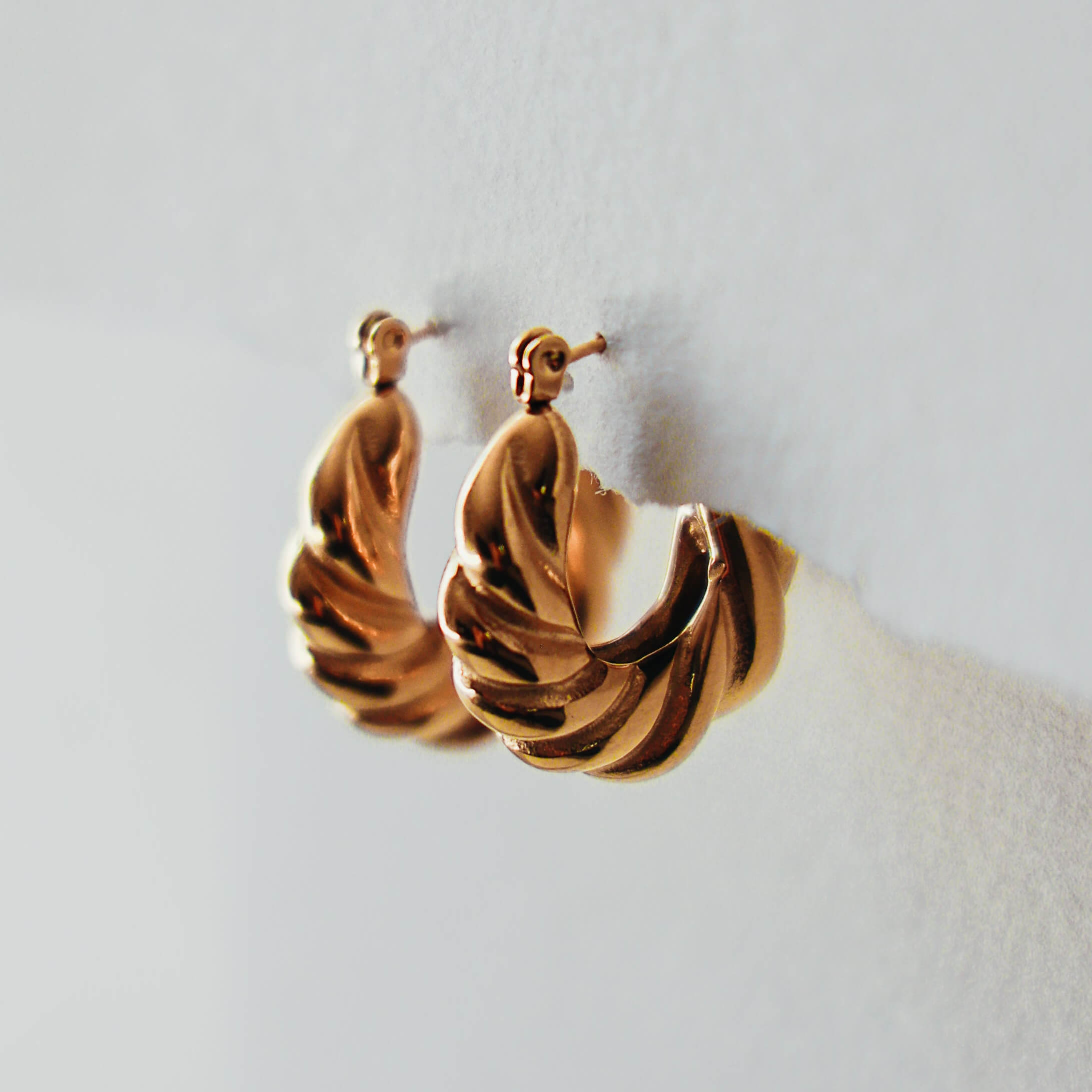 Pair of gold hoop earrings on a light background