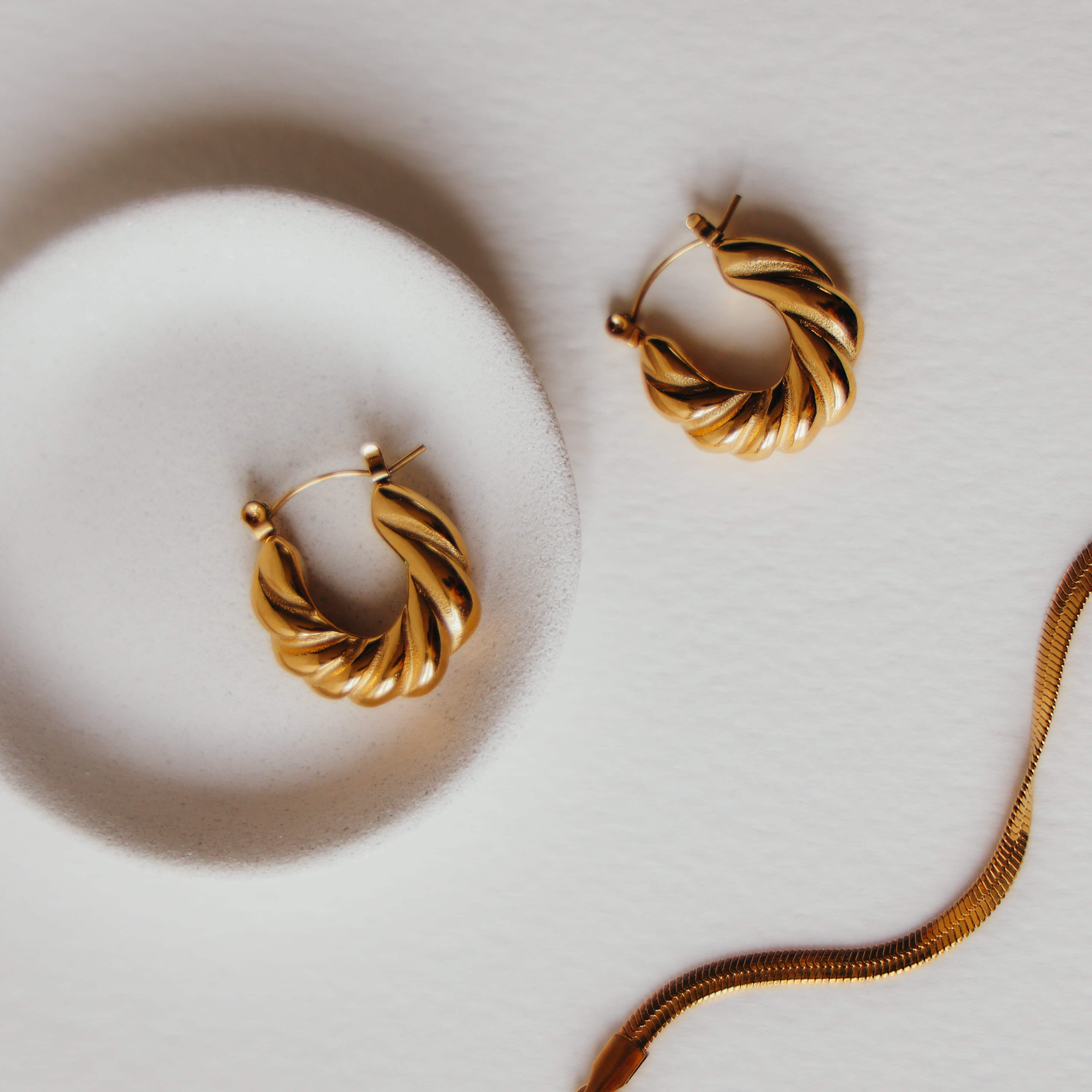 Pair of gold hoop earrings on a light background
