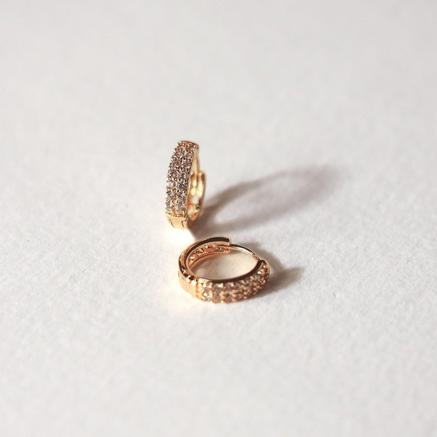 Pair of gold hoop earrings on a light gray background