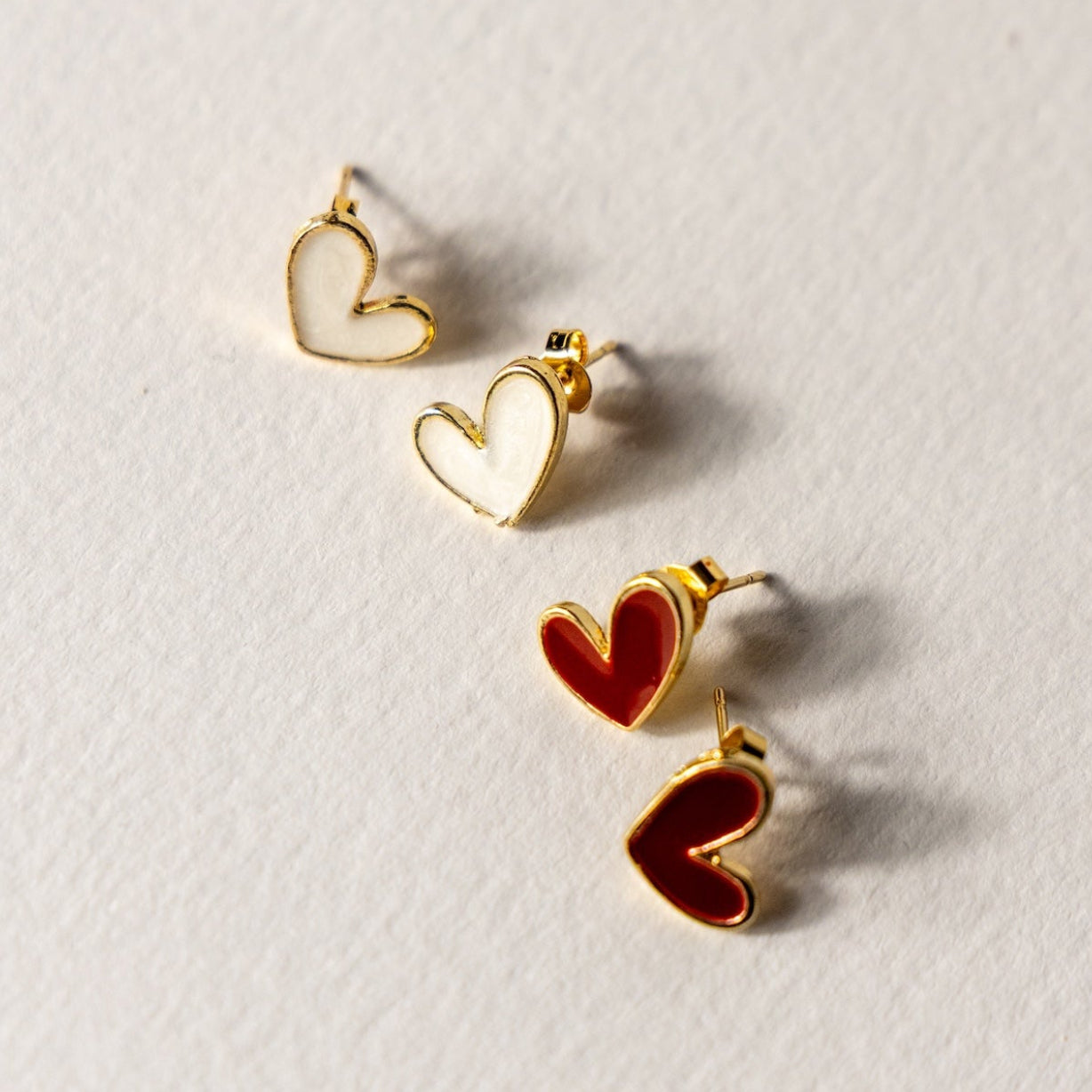 Heart-shaped earrings on a light gray background