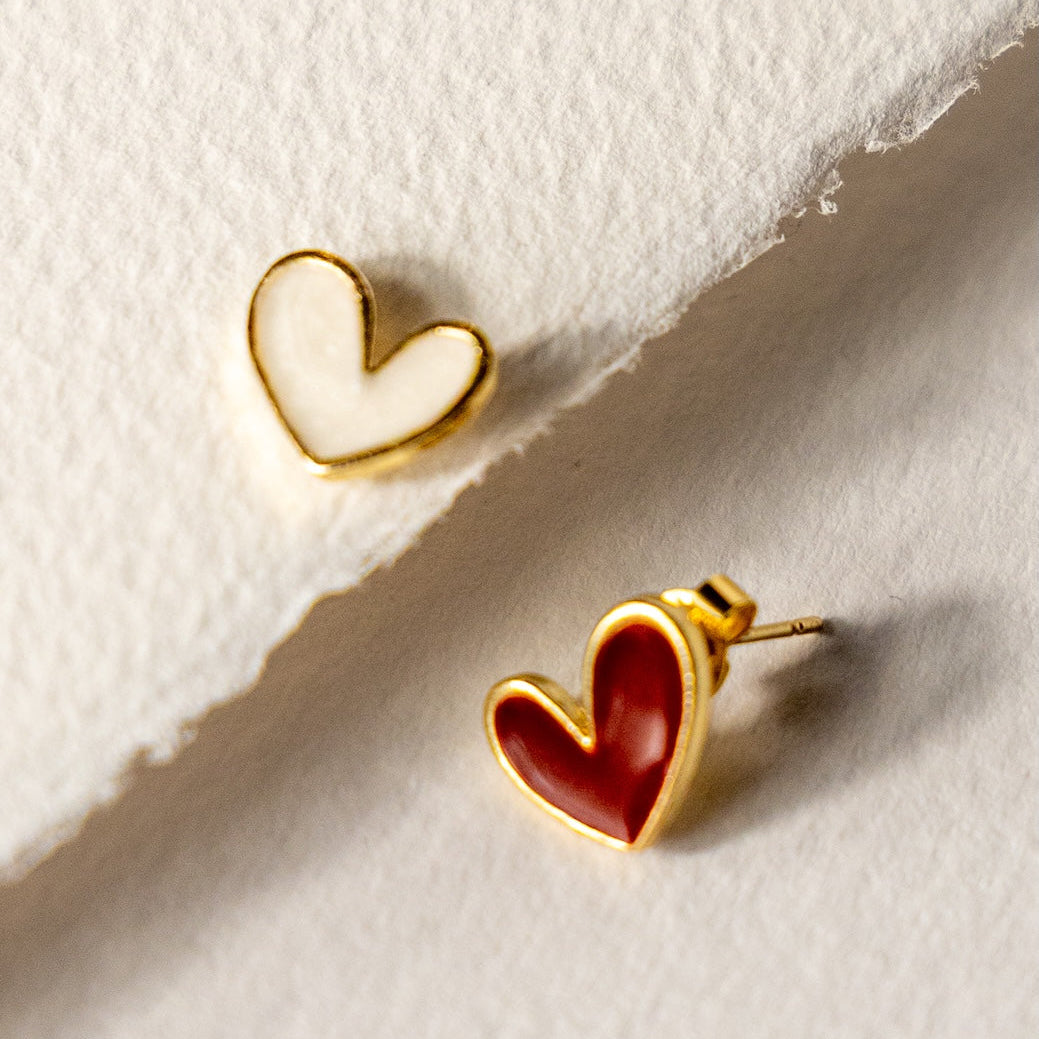 Heart-shaped earrings on a textured white surface