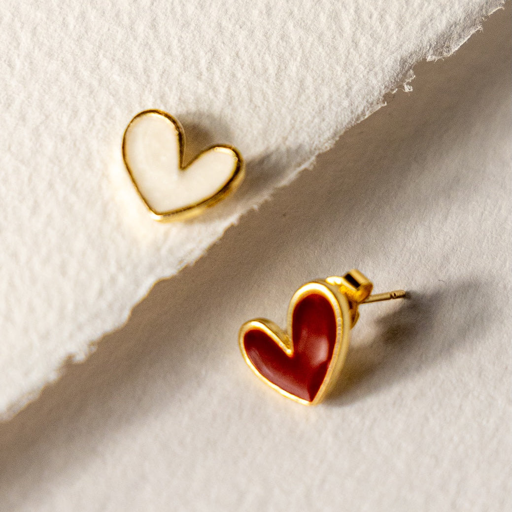 Heart-shaped earrings on a textured white surface