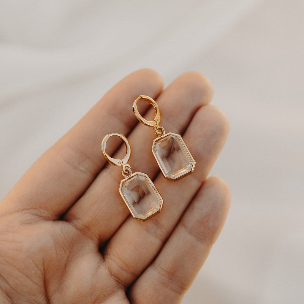Allana faceted drop earrings held in a hand, showing their size