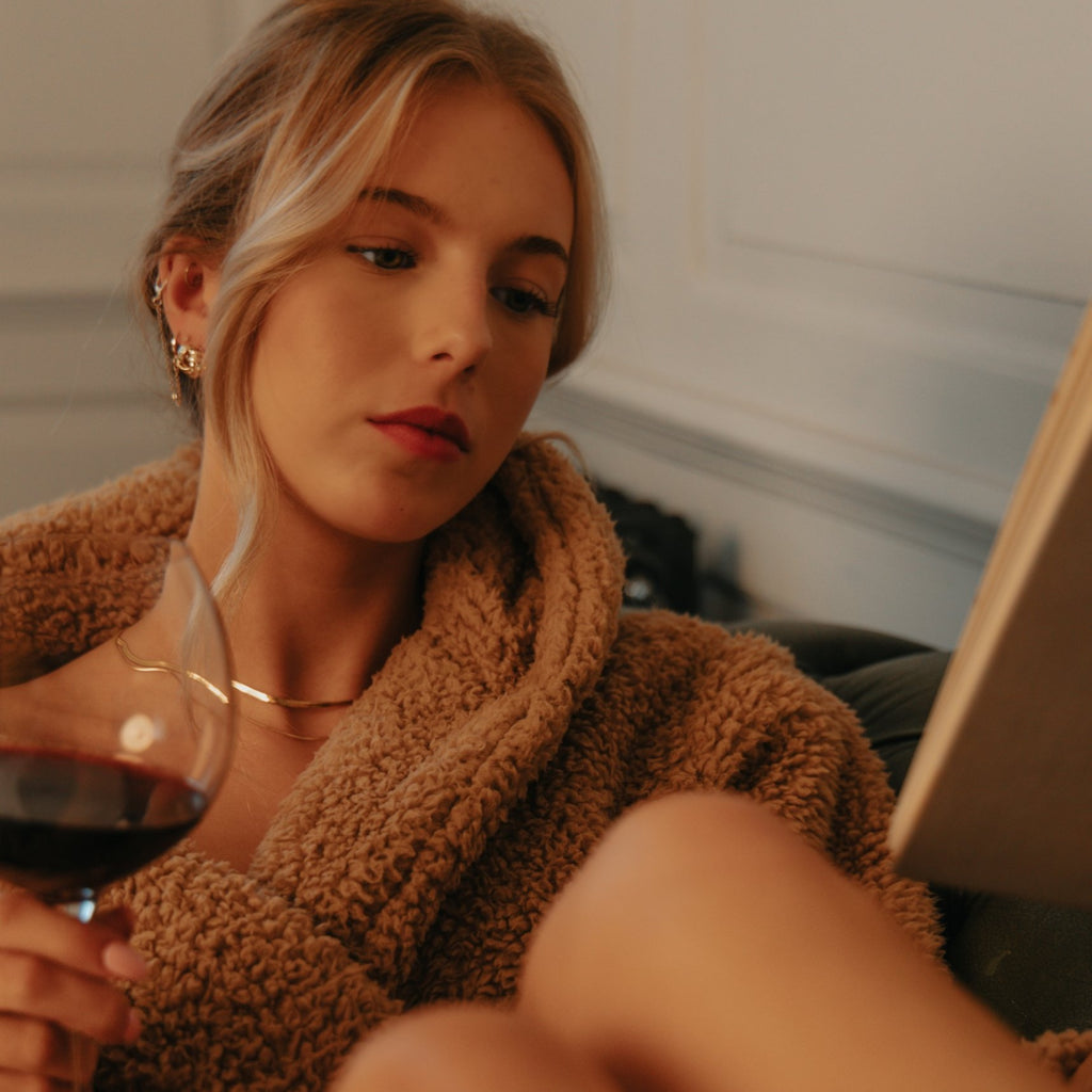 Woman in a fluffy jumper wearing the Beatrice knot studs and Laura double chain necklace