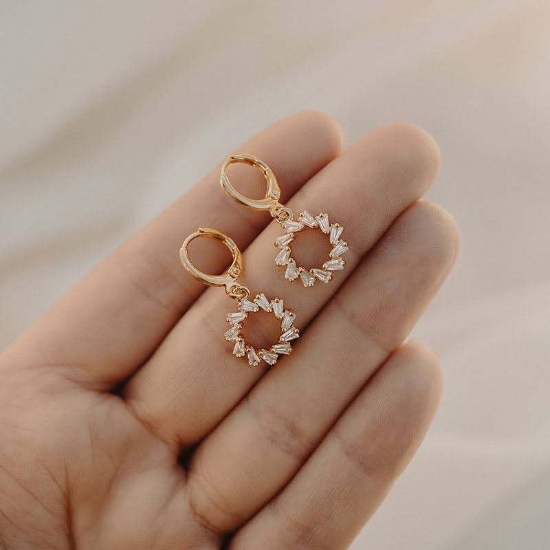 Lucy earrings held on fingers, showing their size